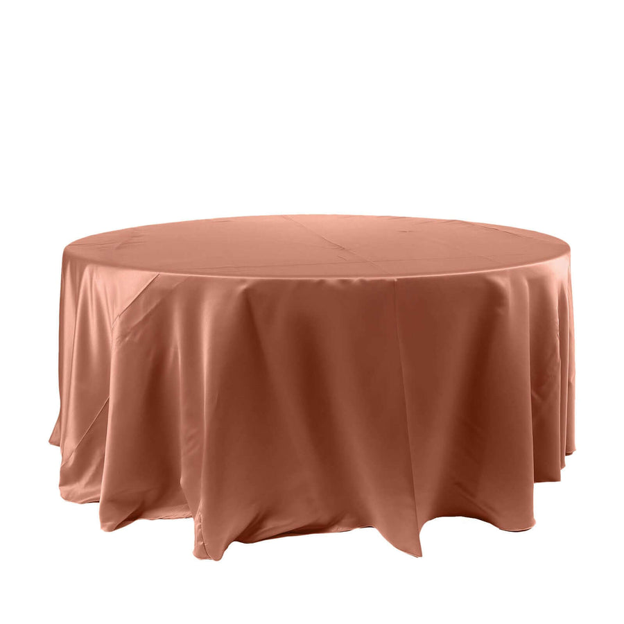 Round table covered with a smooth, peach-colored tablecloth.