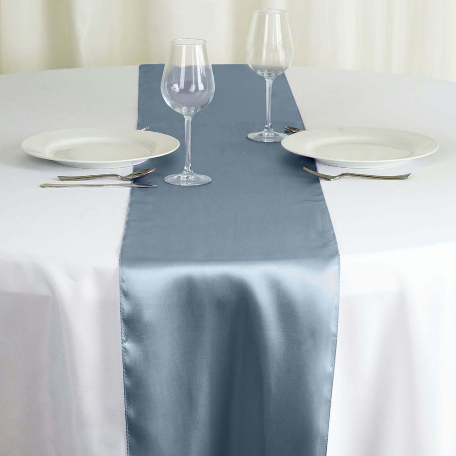 Elegant blue satin table runner on a white dining table with plates and glasses. #whtbkgd