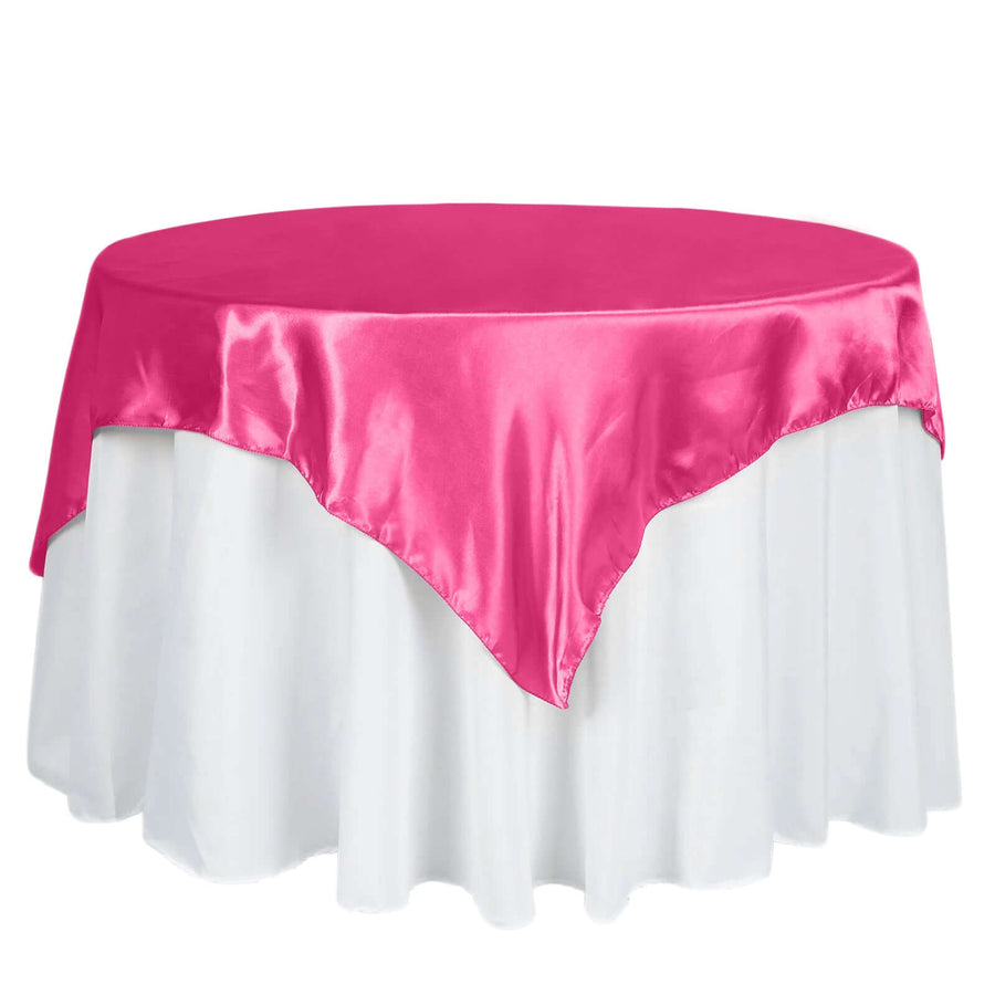Pink satin tablecloth draped over a round table.