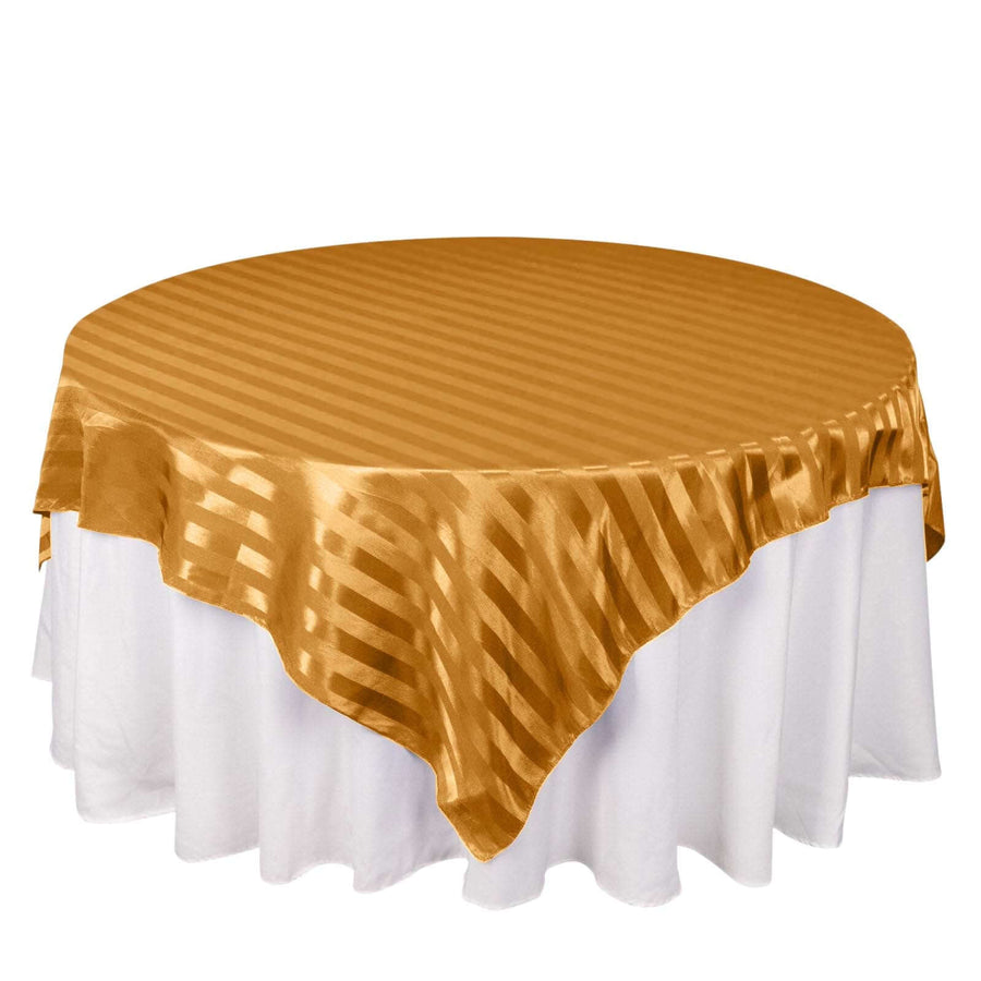 Gold striped tablecloth draped over a round table.