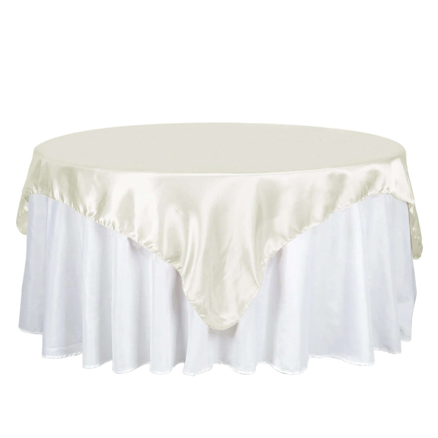 Round table with elegant ivory satin tablecloth