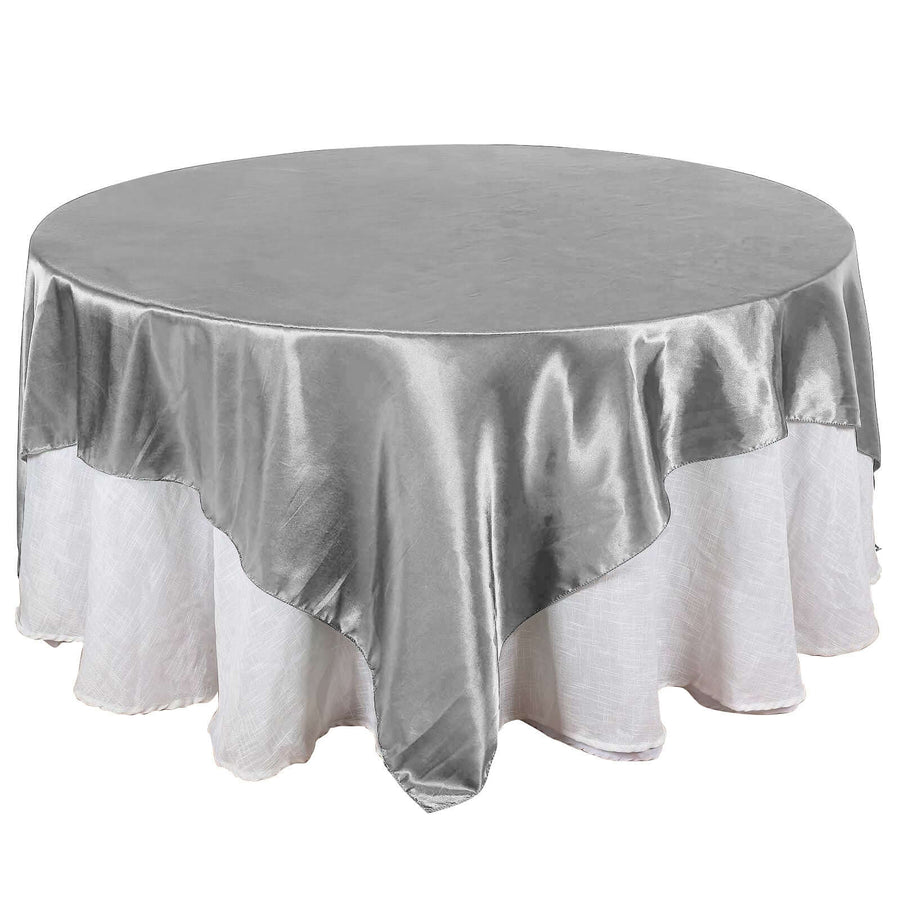 Round silver tablecloth with elegant drape, perfect for events and dining.