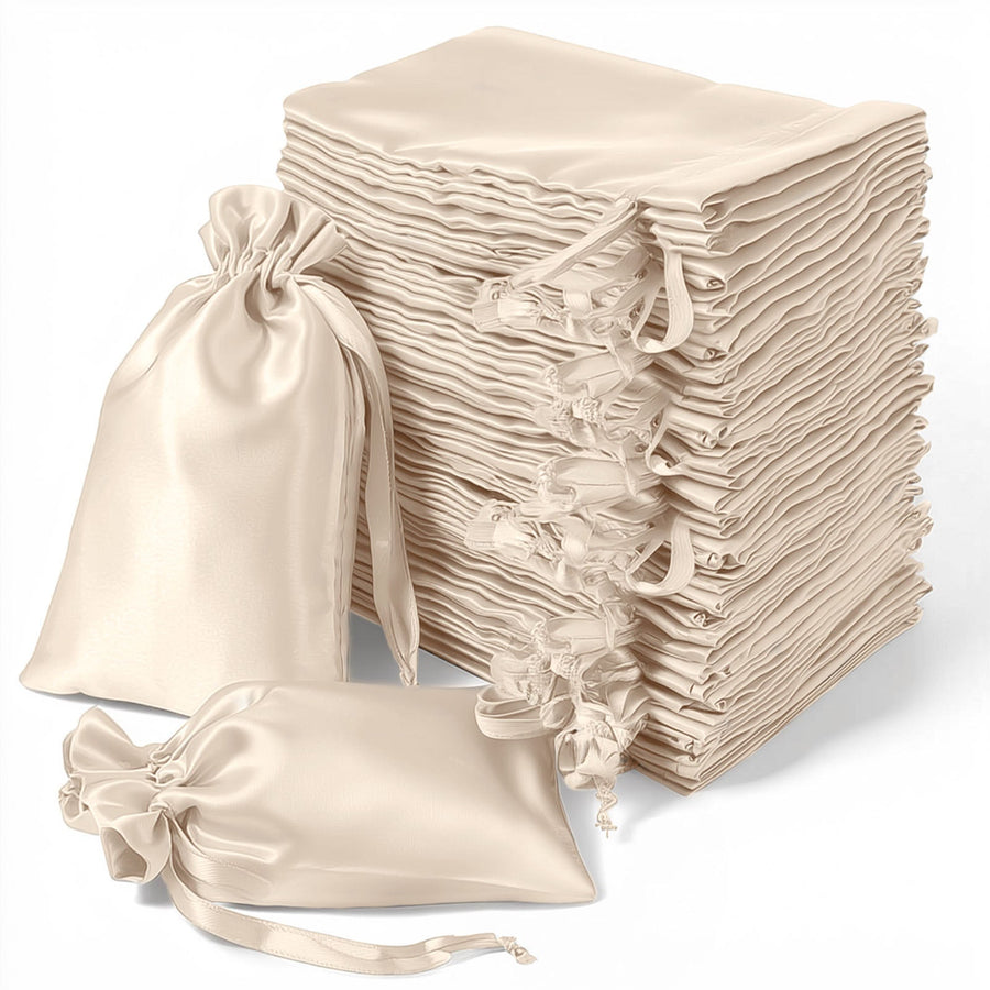Stack of cream satin drawstring bags on a white background.