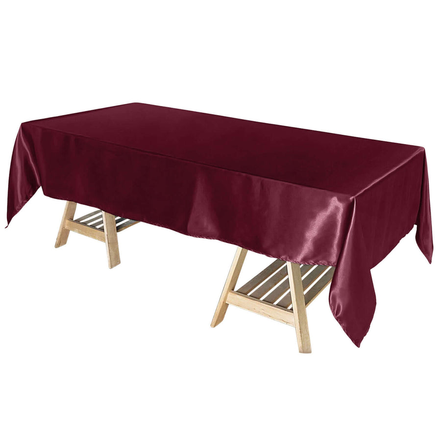 Burgundy satin tablecloth draped over a wooden table