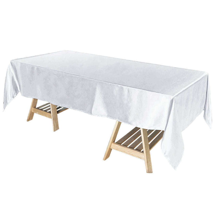White satin tablecloth draped over a wooden table.