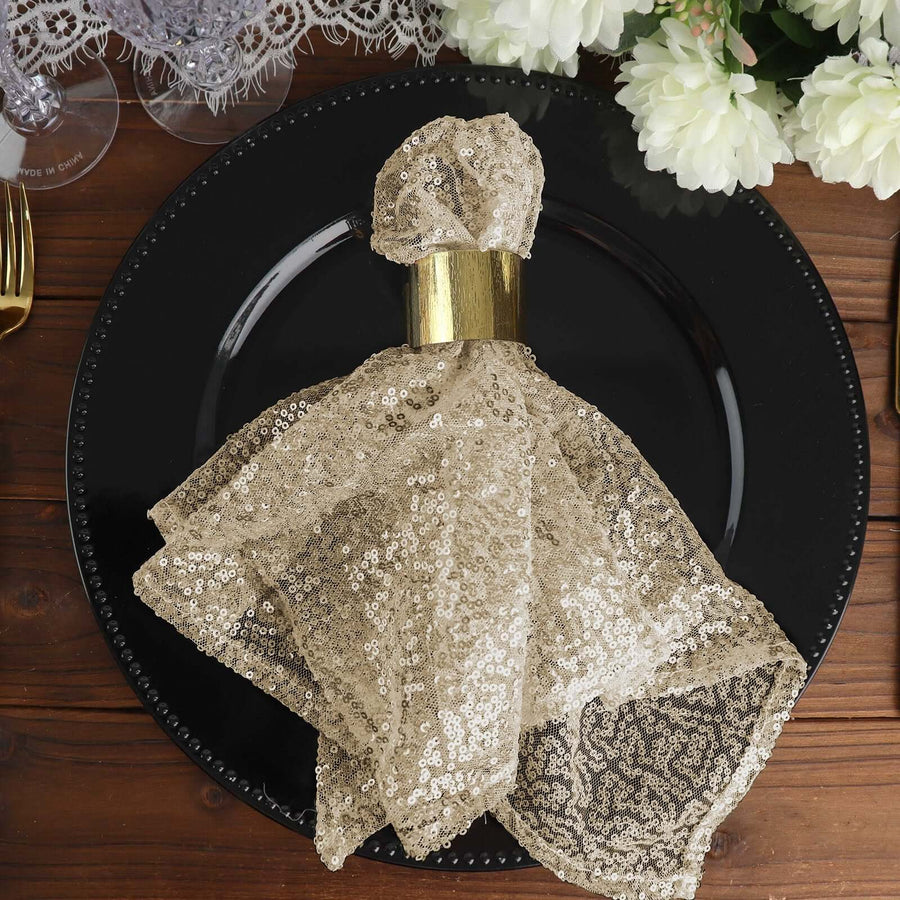 Gold sequin napkin on a black plate, elegantly styled for a dining setting.