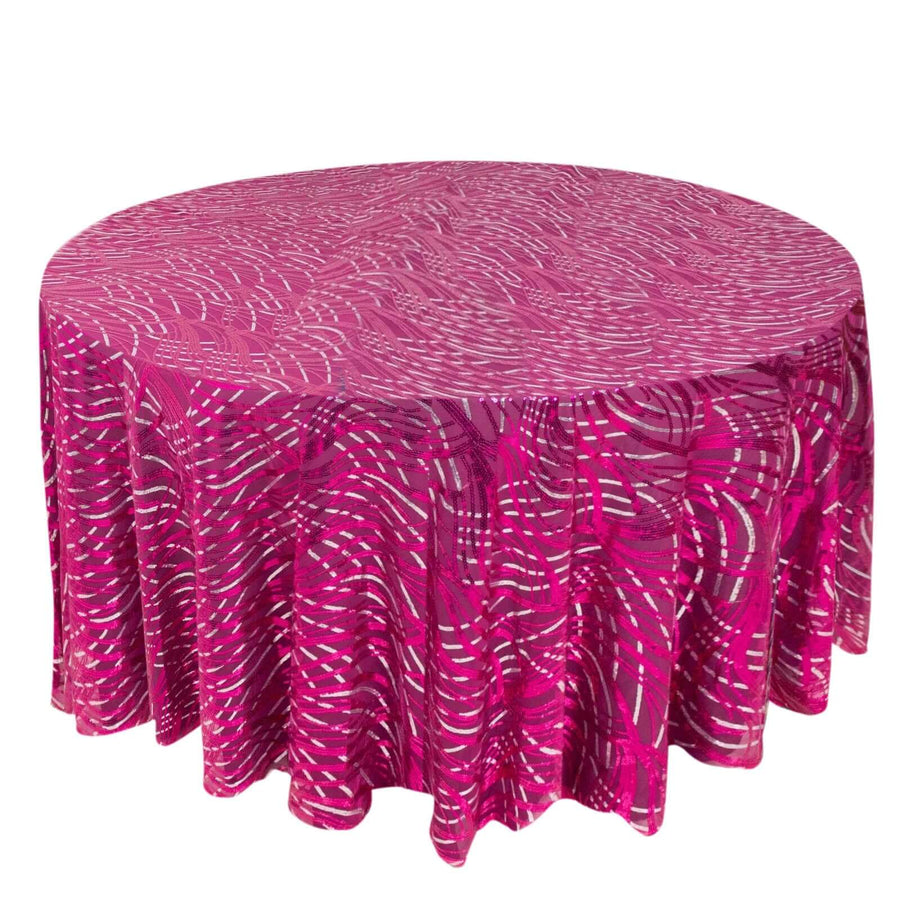 Round pink tablecloth with abstract white patterns on a plain background.