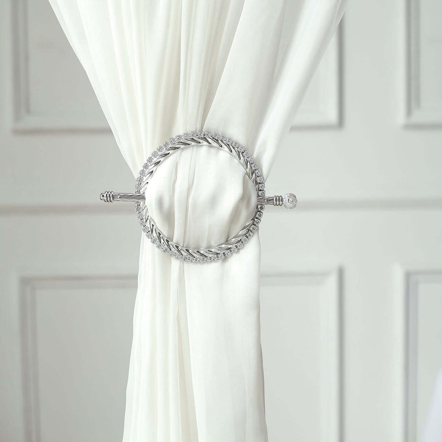 Silver curtain tieback with braided design on a white curtain
