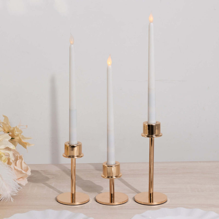 Gold candle holders with white candles, elegant home decor display.