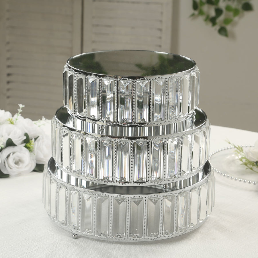 Three tiered silver cake stands with decorative detailing.
