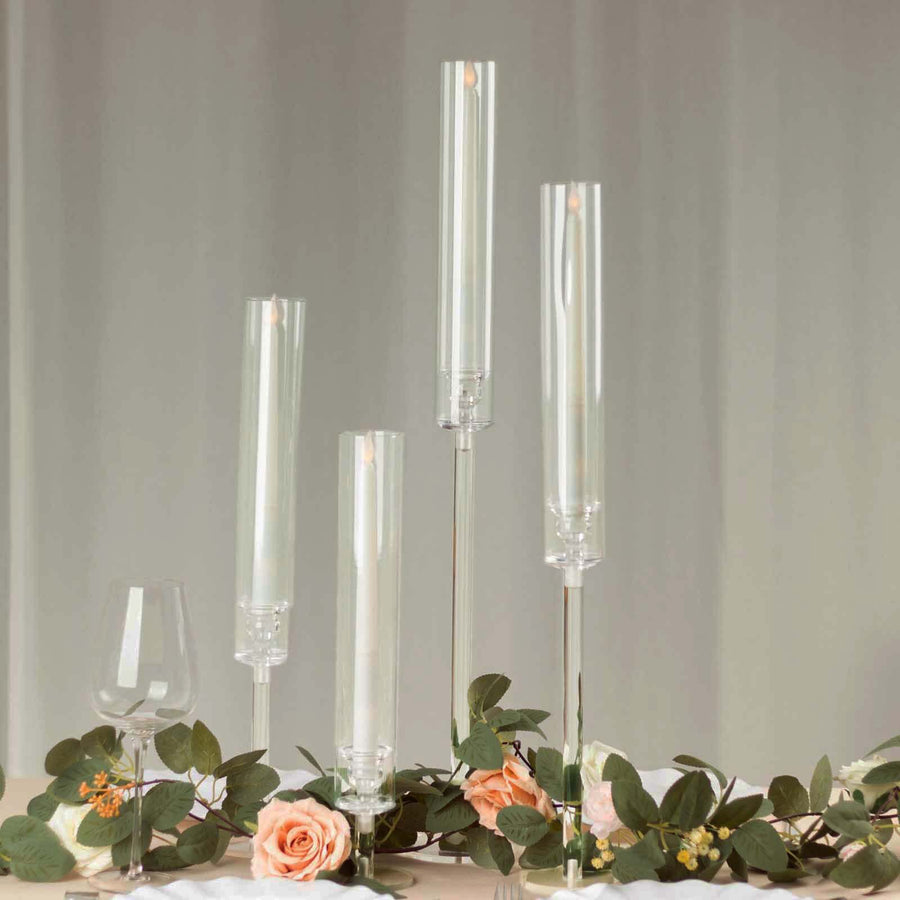 Elegant glass candle holders with white candles and floral accents.