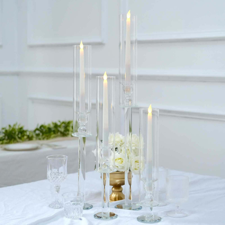 Elegant glass candle holders with LED candles, arranged on a table.