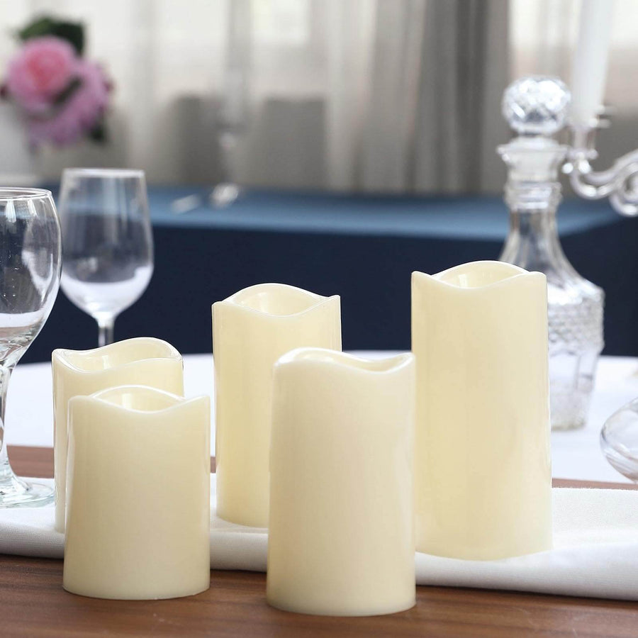 Set of five ivory pillar candles for elegant table decor.