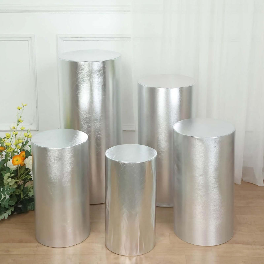 Set of five metallic silver display pedestals in various heights.