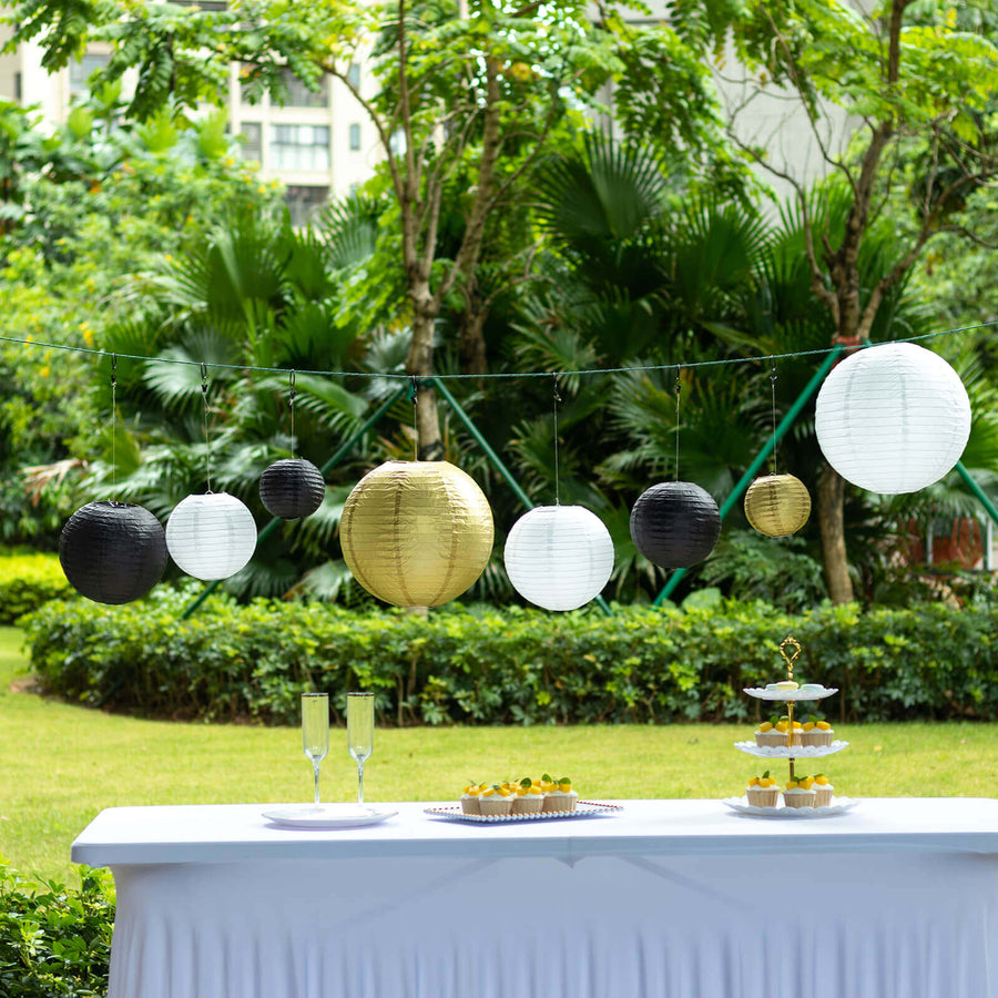 Decorative paper lanterns in black, white, and gold at an outdoor event setting.