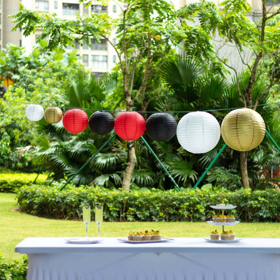 Colorful paper lanterns hanging in a garden setting with a table display.