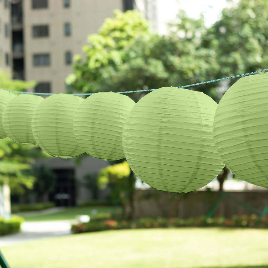 Green paper lanterns hanging outdoors in a garden setting.