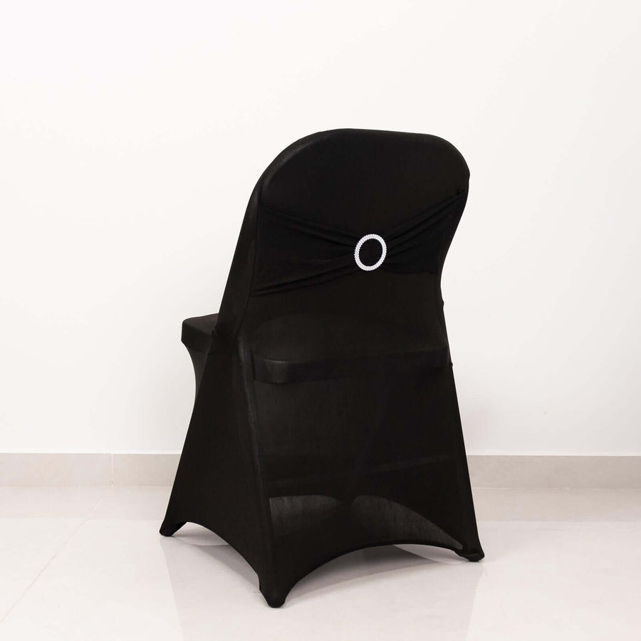 Black chair cover with decorative ring detail on a plain backdrop