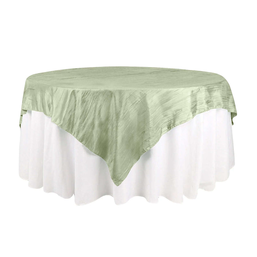 Green satin tablecloth draped over a round table.