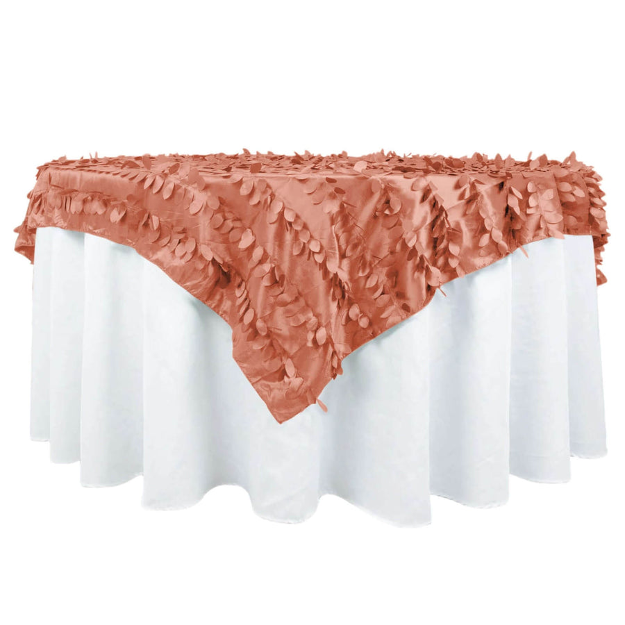 Rose gold tablecloth with leaf design on white table.