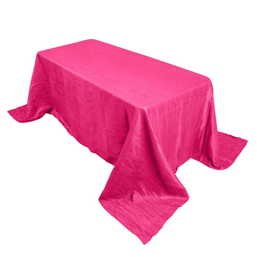 Pink tablecloth draped over a rectangular table on a plain background.