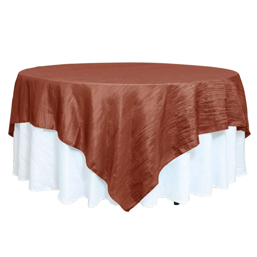 Brown round tablecloth with white ruffled trim on a table.