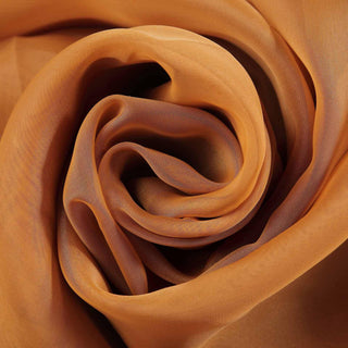Close-up of soft, orange sheer fabric in a swirling pattern.