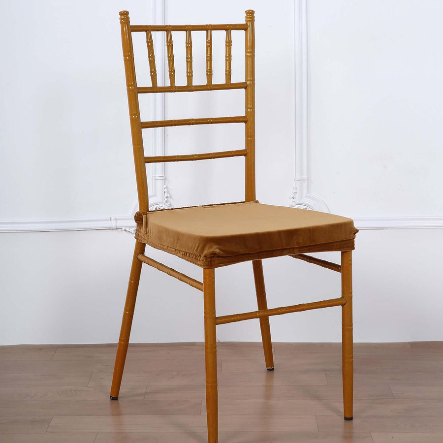 Gold bamboo chair with a tan cushion on a plain background.