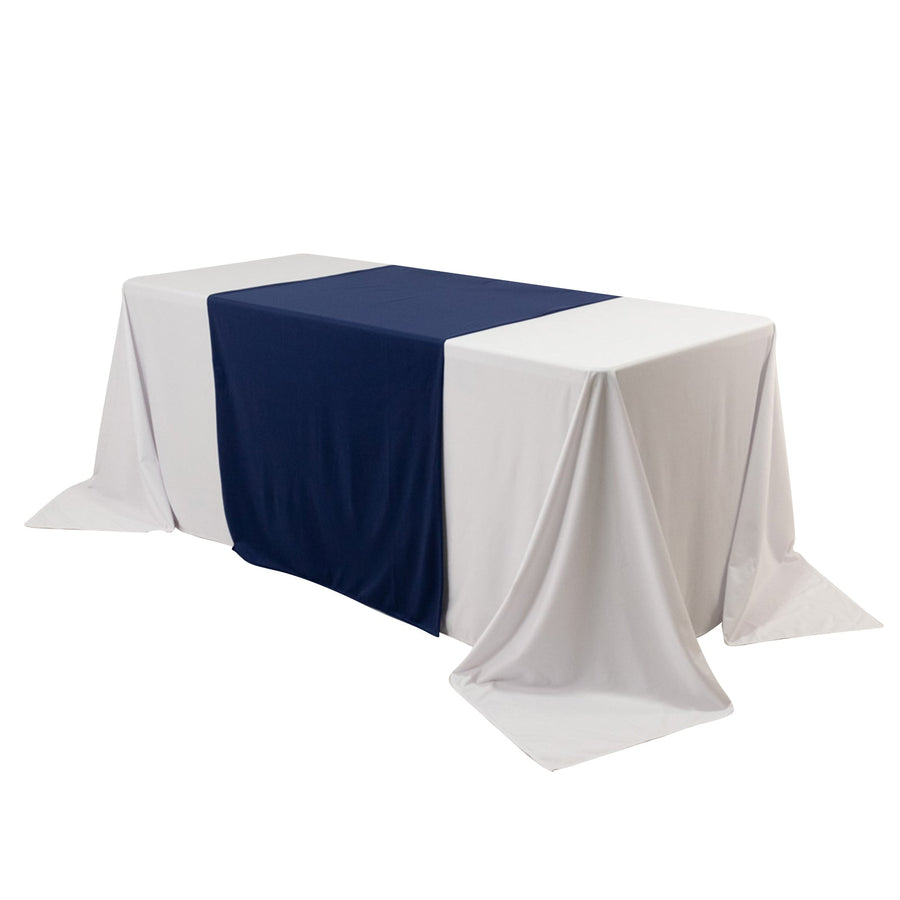 Table with white and navy tablecloths on a plain backdrop