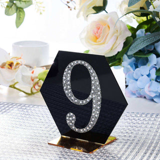 Elegant table number sign with rhinestones, hexagonal shape, black and gold accents.