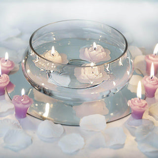 Floating candles in a glass bowl surrounded by rose petals.