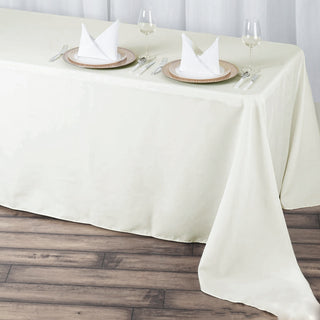 Elevate Your Event with the 90x156 Ivory Seamless Premium Polyester Rectangular Tablecloth