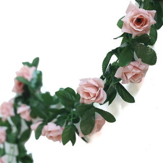 Pink rose garland with green leaves on a white background