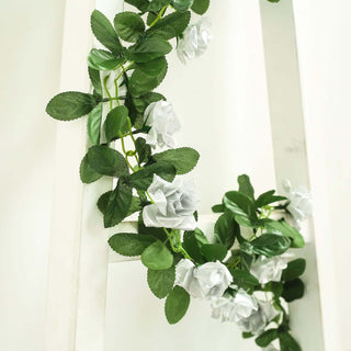 Artificial white rose garland with green leaves on a white background.