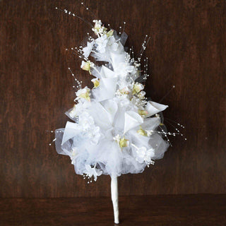 White floral bouquet with lace and decorative elements on a rustic background.