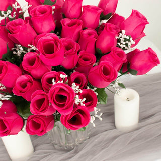 Vibrant pink rose bouquet with white accents in a clear vase.