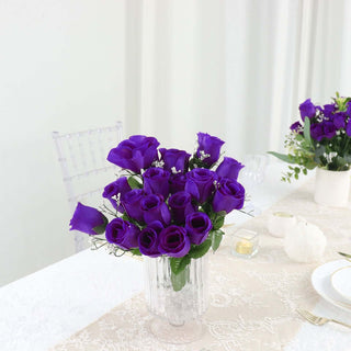Purple rose bouquet in a clear vase on a table setting.