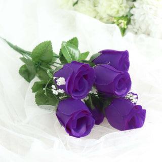 Purple artificial roses bouquet with green leaves.