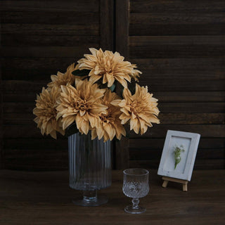 Bouquet of beige flowers in a glass vase on a wooden table.