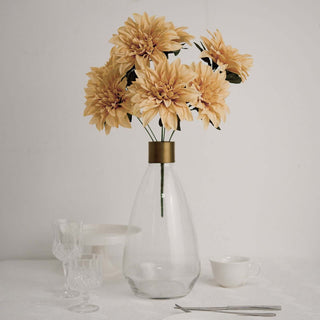 Clear glass vase with artificial sunflowers, elegant table setting.