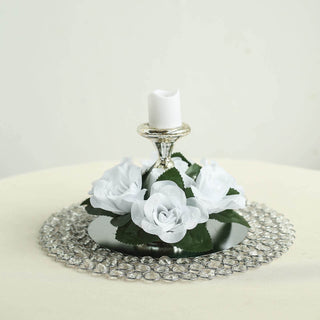 Elegant candle holder with white roses and a mirrored base.