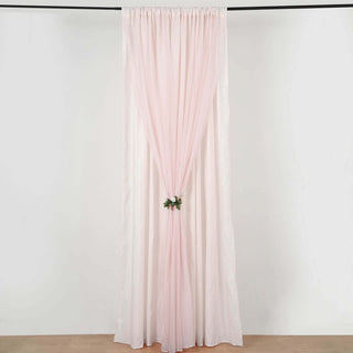 Pink sheer curtain with floral tieback, styled in a studio setting.