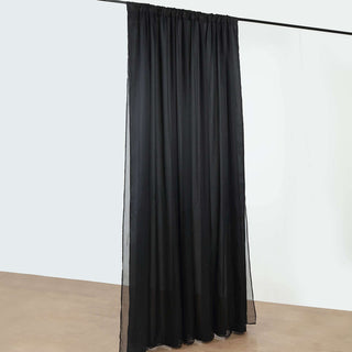 Black sheer curtain panel hanging from a rod