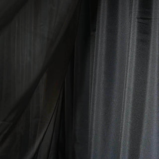 Black fabric draped elegantly, showcasing soft texture and rich color.
