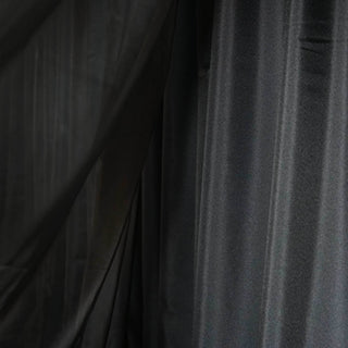 Black sheer fabric draped elegantly in soft folds. #whtbkgd