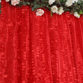 Red fabric backdrop with floral accents for events and photography.