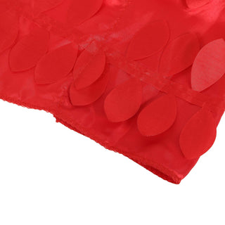Red fabric with leaf-shaped appliqués on a plain background.