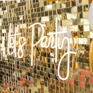 Neon "Let's Party" sign against a shiny gold backdrop.