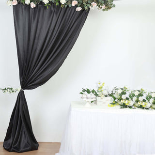 Elegant black drapery with floral accents and a decorated table