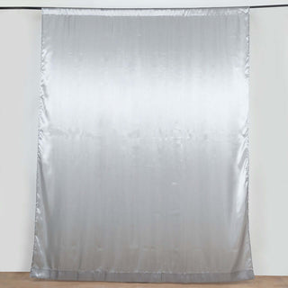 Silver satin curtain draped elegantly against a neutral background.